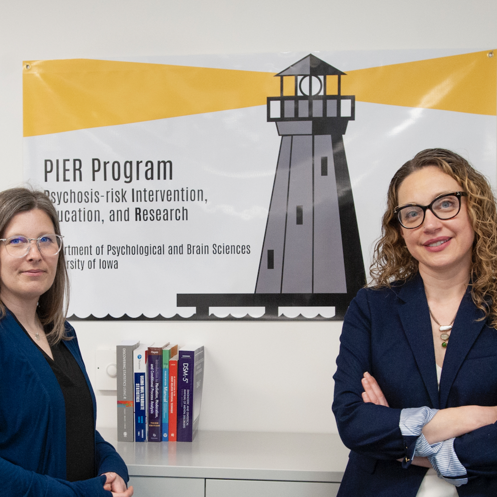 Assistant professors McCleery and Baran stand in front of PIER Program poster